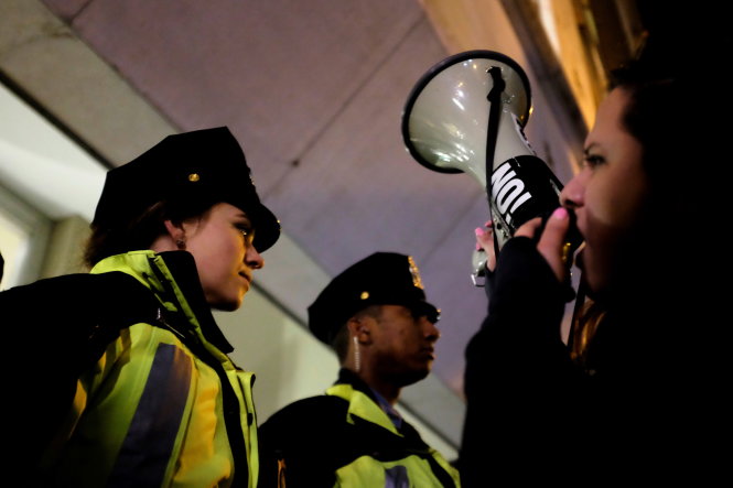 Demonstrators against U.S. President-elect Donald Trump confront police outside the National Press Building while the Deploraball is underway in Washington, U.S., January 19, 2017.