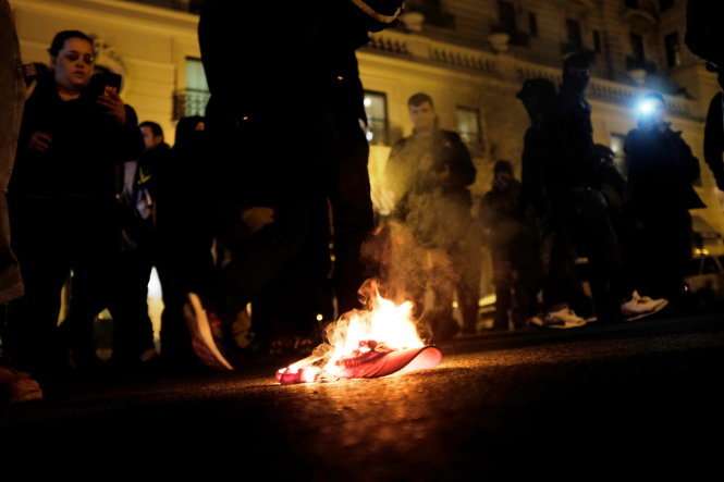 Demonstrators against U.S. President-elect Donald Trump burn a red 