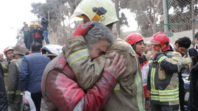 Một nhân viên cứu hỏa đang được đồng nghiệp động viên sau sự cố thảm khốc - Ảnh: REUTERS