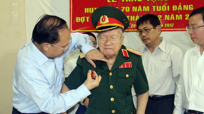 Ông Tất Thành Cang gắn huy hiệu 70 năm tuổi Đảng đến ông Nguyễn Xuân Ôn vào chiều 20 -1 - Ảnh: M.Phượng