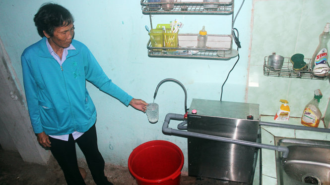 Một người dân ở huyện Củ Chi được cấp nước sạch thông qua thiết bị lọc nước hộ gia đình - Ảnh: Q.Khải