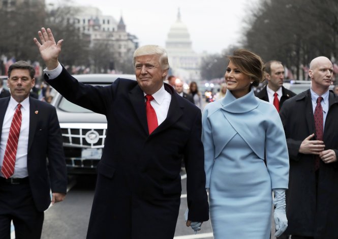 Ông Donald Trump vẫy tay khi cùng bà Melania Trump và con trai Barron của họ diễu hành trên đại lộ Pennsylvania tại Washington - Ảnh: Reuters