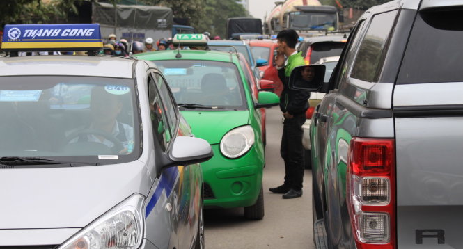 Không thể nhúc nhích, tài xế lái xe taxi đã xuống xe hút thuốc - Ảnh: Chí Tuệ