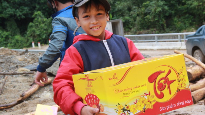 Cậu bé Hồ Quang Huy hớn hở khi được nhận thùng bánh kẹo tết