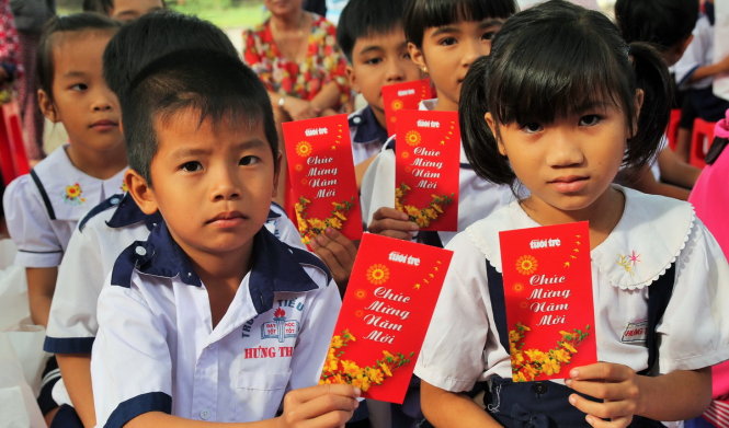 Các em học sinh Trường tiểu học Hưng Thạnh, tỉnh Tiền Giang phấn khởi khi được nhận lì xì sớm - Ảnh: Mậu Trường