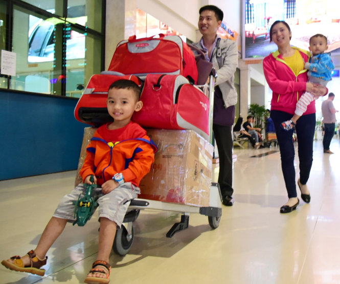 Tại sân bay Tân Sơn Nhất, nhiều gia đình đưa con về quê ăn tết - Ảnh: HỮU THUẬN
