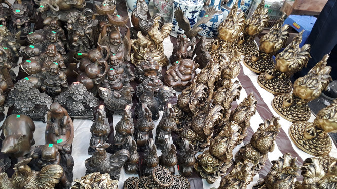 Nhiều sản phẩm đúc đồng tinh xảo, là vật phẩm trang trí phong thủy dịp Tết được bày bán trên các con phố đi bộ tại chợ Đồng Xuân - Ảnh: NGỌC AN