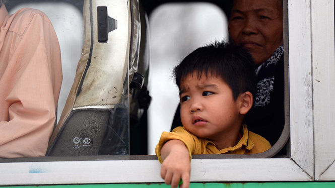 Một em nhỏ mệt mỏi ngồi trên xe buýt vì kẹt xe - Ảnh: HỮU KHOA