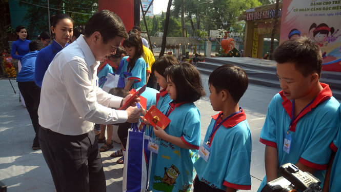 Ông Nguyễn Thành Phong - Ủy viên BCH Trung ương Đảng, Phó bí thư Thành ủy TP.HCM, Chủ tịch UBND TP.HCM tặng quà và lì xì cho các trẻ em có hoàn cảnh đặc biệt khó khăn - Ảnh: QUANG PHƯƠNG