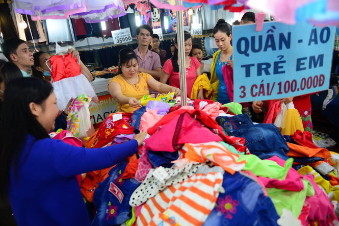Công nhân mua sắm quần áo tại hội chợ mua sắm dành cho công nhân tại Khu chế xuất Tân Thuận (Q.7, TP.HCM) tối 22-1 - Ảnh: QUANG ĐỊNH