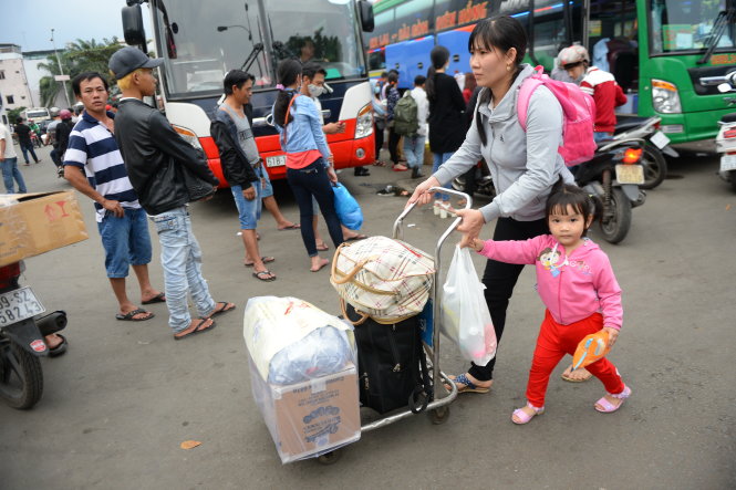 Hai mẹ con chị Nguyễn Thị Lan (Nha Trang) đẩy xe đồ và quà tết về quê biếu gia đình - Ảnh: HỮU KHOA