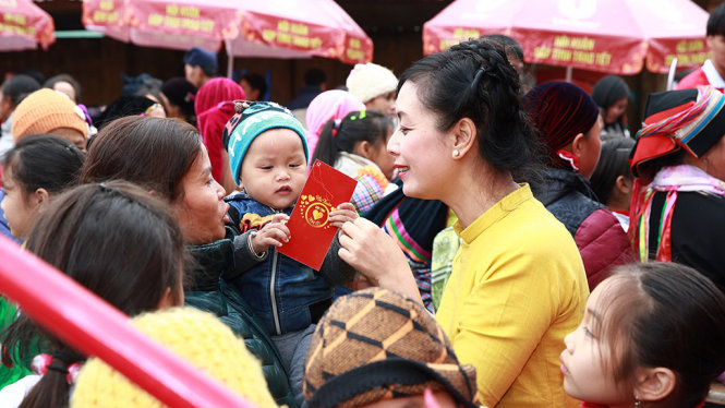 Nghệ sĩ Chiều Xuân tặng quà cho một em bé ở Hà Gian - Ảnh: CT