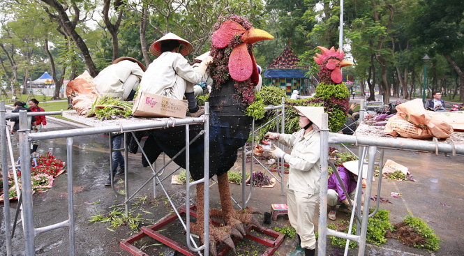 Các chú gà còn lại đang được các công nhân gấp rút hoàn thiện bằng việc gắn cỏ và hoa - Ảnh: NAM TRẦN