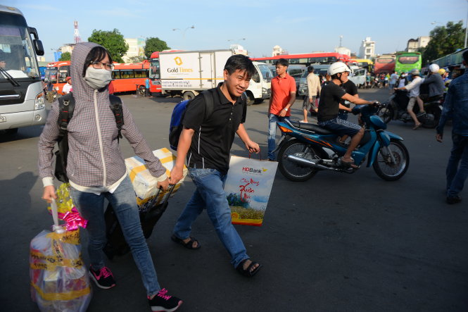 Hai anh em Nguyễn Ngọc Duy (Phú Yên) hăm hở mang bánh mứt và quần áo về làm quà tết cho gia đình - Ảnh: HỮU KHOA