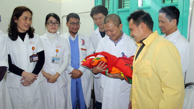 Gs Lê Ngọc Thành, người bế em bé và bố bé cùng các nhân viên y tế