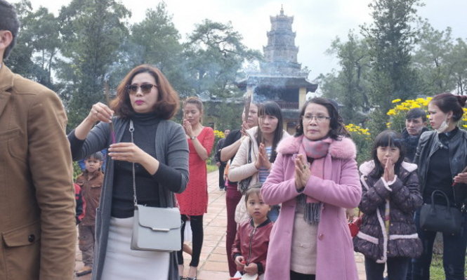 Đi lễ chùa ngày đầu năm là một nét đẹp trong văn hóa Việt Nam. Trong ảnh: một gia đình đi lễ chùa Thiên Mụ (Huế) sáng sớm mùng 1 tết 2016 - Ảnh: CHÂU ANH
