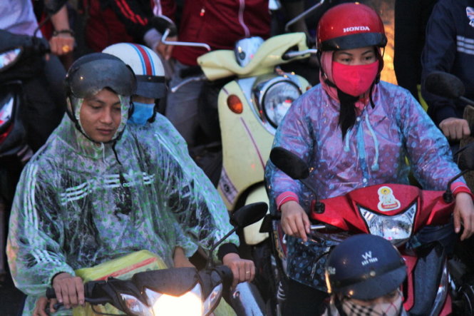 Nhiều người mệt mỏi sau một chặng đường dài từ TP.HCM đến Tiền Giang bị mắc mưa - Ảnh: Mậu Trường