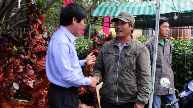 Ông Võ Ngọc Kha - chủ tịch UBND TP Tuy Hòa - động viên người bán hóa tết tại Hội hoa xuân TP Tuy Hòa sáng 29 tháng Chạp - Ảnh: Thanh Hội