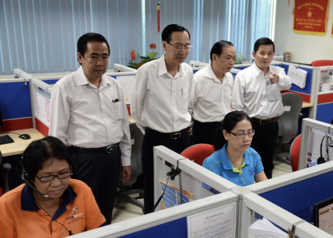 Đoàn lãnh đạo TP.HCM thăm các nhân viên trực đường dây nóng đêm giao thừa - Ảnh: Tự Trung