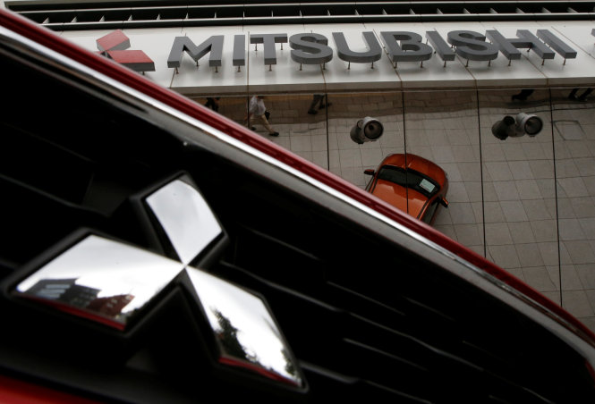 Mitsubishi Motors Corp's logo on a car and its company headquarters are seen in Tokyo, Japan, August 2, 2016