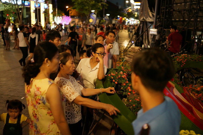 Có nhiều người lớn tuổi cũng đứng đợi để xin những chậu hoa được trang trí trên đường hoa Nguyễn Huệ dịp tết 2017 - Ảnh: HỮU THUẬN