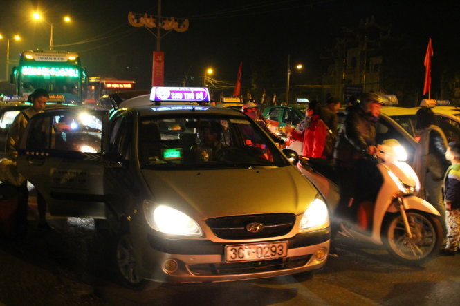Xe taxi đỗ hàng dài, cộng với việc người dân tràn ra đường bắt xe cho kịp giờ làm việc khiến cửa ngõ bến xe Nước Ngầm ùn tắc từ sáng
