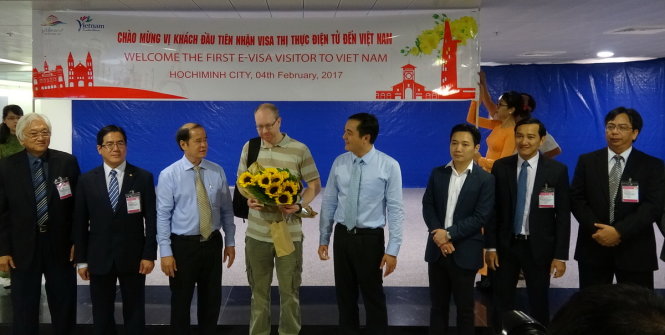 TP.HCM đón vị khách quốc tế đầu tiên được cấp thị thực điện tử VN tại sân bay Tân Sơn Nhất. Vị khách này là ông Richard Kenneth Wilson (quốc tịch Anh - áo thun) đến VN từ chuyến bay QR970 - Ảnh HOÀI PHƯƠNG