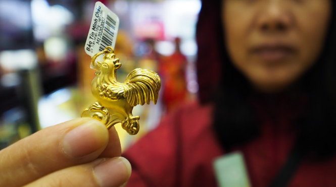 Một người dân cầm trên tay con gà bằng vàng có trọng lượng hơn một chỉ, do là năm Đinh Dậu nên mặt hàng này bán khá chạy - Ảnh: Nguyễn Khánh