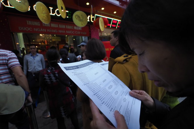 Một người dân đang chăm chú theo dõi một bảng giá vàng trước chi chọn mua - Ảnh: Nguyễn Khánh