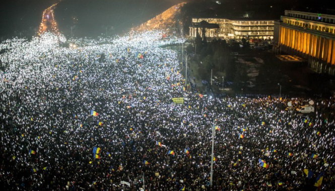 Người biểu tình bật đèn điện thoại di động khi tham gia biểu tình đêm 5-2 - Ảnh: AFP