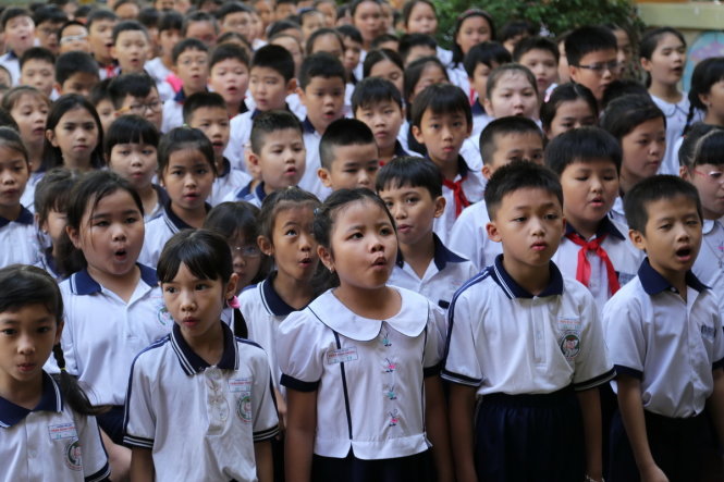 Học sinh trường tiểu học Trần Bình Trọng chào cờ đầu tuần trong buổi đầu tiên trở lại lớp sau hơn 2 tuần nghỉ tết sáng 6-2 - Ảnh: NHƯ HÙNG