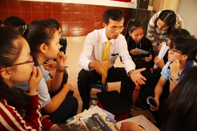 TS Lê Tuấn Lộc - phó hiệu trưởng Trường ĐH Kinh tế - luật (ĐHQG TP.HCM) đang tư vấn tuyển sinh cho các học sinh - Ảnh: TRẦN HUỲNH