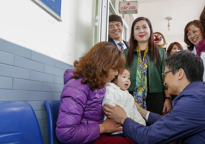 Phó thủ tướng Vũ Đức Đam trò chuyện với một phụ huynh có con đi khám tại Trạm Y tế phường Tây Mỗ (Nam Từ Liêm, Hà Nội) - Ảnh: VIỆT DŨNG