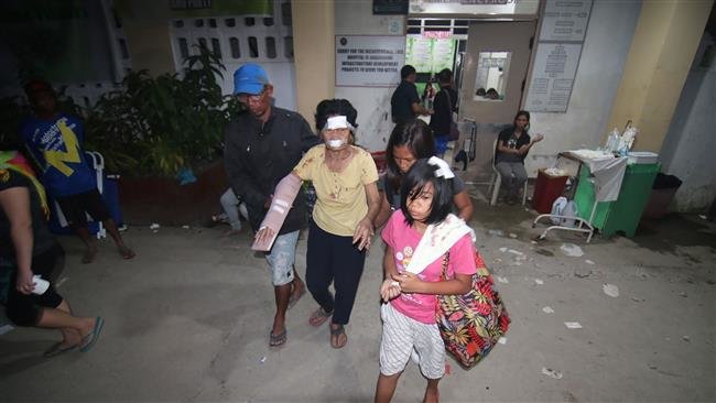 Một người bị thương được gia đình đưa đến bệnh viện sau động đất - Ảnh: AFP