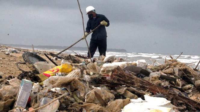 Công nhân dọn lượng lớn rác tấp vào bờ biển - Ảnh: LÊ TRUNG