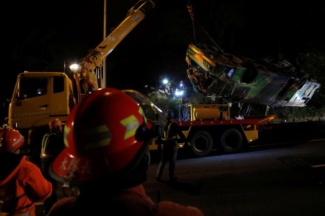 Huy động xe cẩu để trục xác xe tai nạn lấy xác người và cứu người bị thương - Ảnh: Reuters