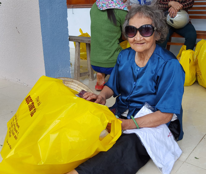 Một bà cụ ở xã Cát Tài vui mừng khi nhận được quà cứu trợ của bạn đọc báo Tuổi Trẻ - Ảnh: Duy Thanh