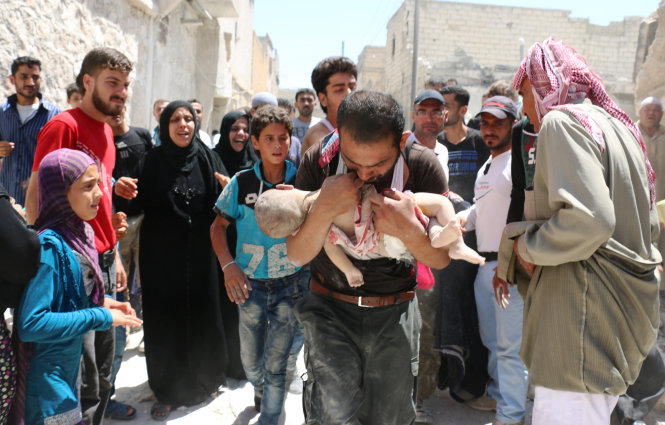 Từng bất đồng, giờ đây Mỹ và Nga đang hợp tác trong cuộc chiến chống IS tại Syria. Trong ảnh: một người Syria ẵm con chạy khỏi đống đổ nát sau trận không kích của quân đội chính phủ vào khu vực chiếm đóng của IS ở thành phố Aleppo hồi tháng 7-2016 - Ảnh: AFP