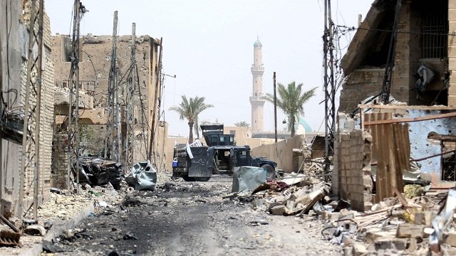 Một chiếc xe của lực lượng quân đội Iraq bị hư hại trên đường phố Fallujah hồi tháng 6-2016 - Ảnh: AFP