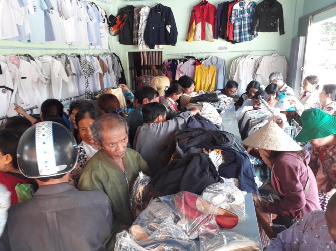 Hàng chục người dân đổ xô vào cửa hàng không đồng để lựa quần, áo và đồ gia dụng mang về cho gia đình mình - Ảnh: Bửu Đấu