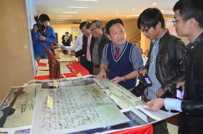 Đại diện Bảo tàng Đà Nẵng (giữa) giới thiệu các hiện vật, tài liệu bàn giao cho tỉnh Quảng Nam - Ảnh: TẤN LỰC