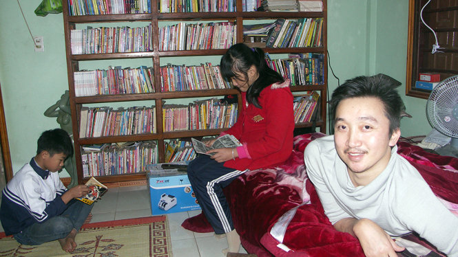 Anh Mai Tư Khoa và niềm vui khi thấy các em học sinh đến mượn sách - Ảnh: LAM GIANG