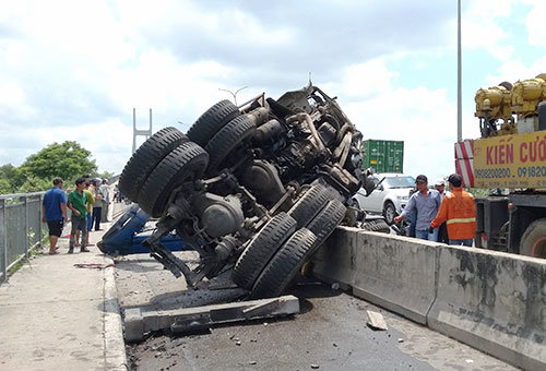 Một xe tải lật nhào văng vào làn xe máy khi vừa đổ dốc cầu Phú Mỹ - Ảnh: Lê Phan