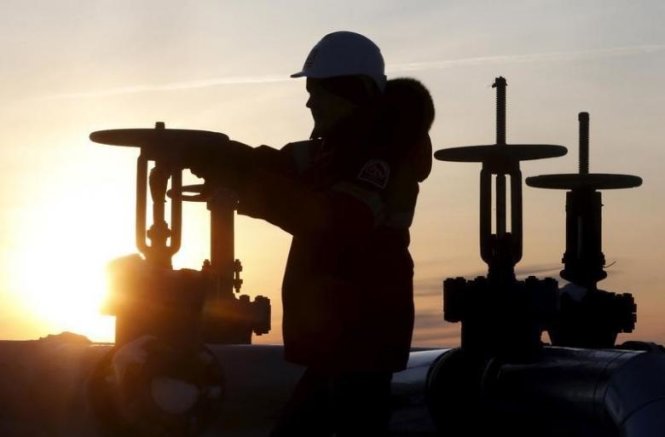 Một công nhân kiểm tra van ống dẫn dầu tại mỏ dầu Imilorskoye thuộc sở hữu của công ty Lukoil bên ngoài thành phố Kogalym - Ảnh: Reuters