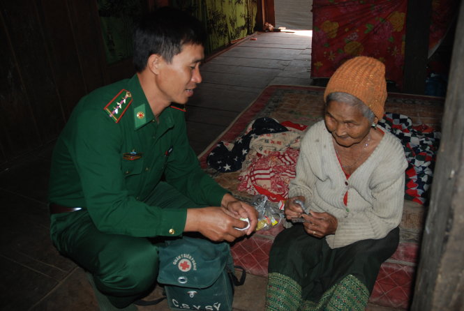 Thượng úy Trà thăm khám cho bà H’Bdui BKrông - người đau ốm nhiều năm tại buôn Đrăng Phốk - Ảnh: B.D.