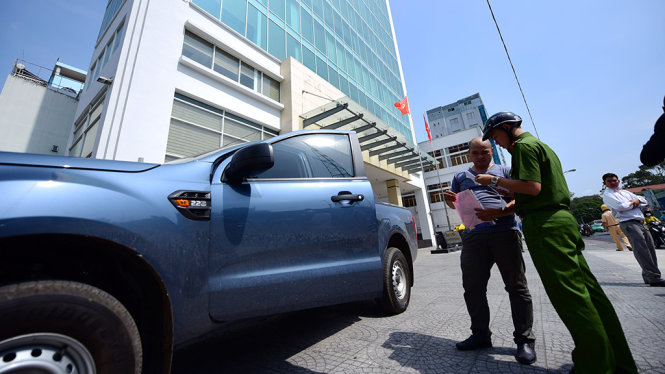 Công an xử phạt tài xế xe ô tô trên vỉa hè trước trụ sở Bộ Công thương trên đường Nguyễn Thị Minh Khai, Q.1 - Ảnh: HỮU THUẬN