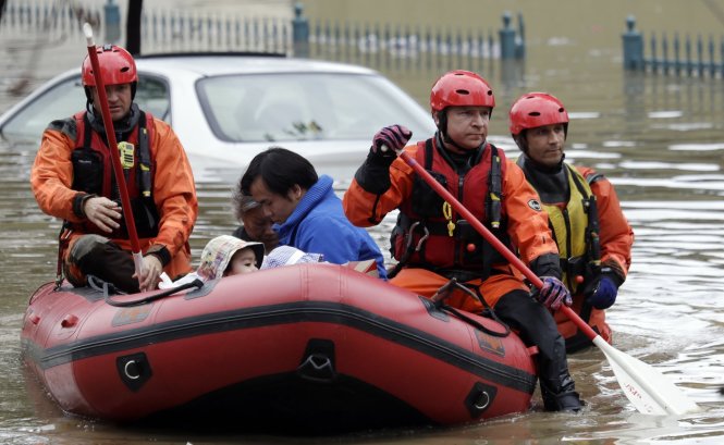 Nhân viên cấp cứu dùng xuồng chở một số cư dân gốc Á ở San Jose khỏi nơi bị lụt - Ảnh: AP