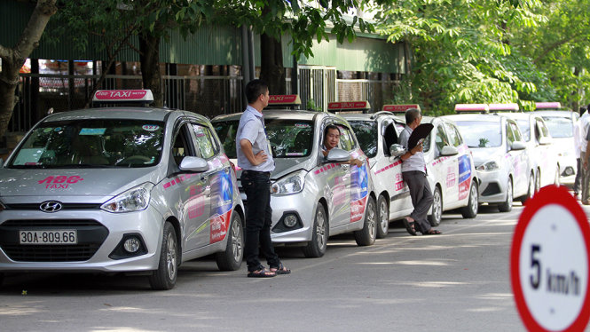 Các doanh nghiệp taxi cho rằng taxi truyền thống bị trói chặt, còn xe Uber, Grap lại thả lỏng - Ảnh: Nam Trần