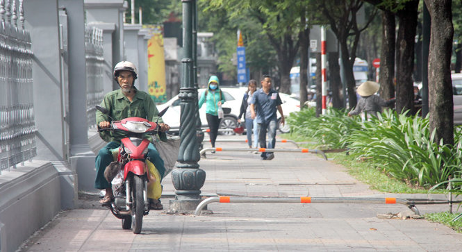 Barie dù có điều chỉnh vẫn không ngăn được tình trạng chạy xe trên vỉa hè. Ảnh chụp trên lề đường Lý Tự Trọng - Ảnh QUANG KHẢI