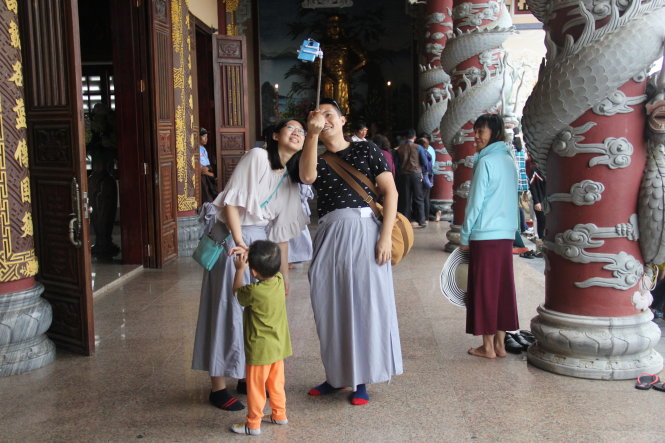 Trang phục không phù hợp, hai du khách Hàn Quốc được mời mặc váy và vui vẻ chụp ảnh với “trang phục mới” khi vào thăm chùa Linh Ứng - Ảnh: Trường Trung